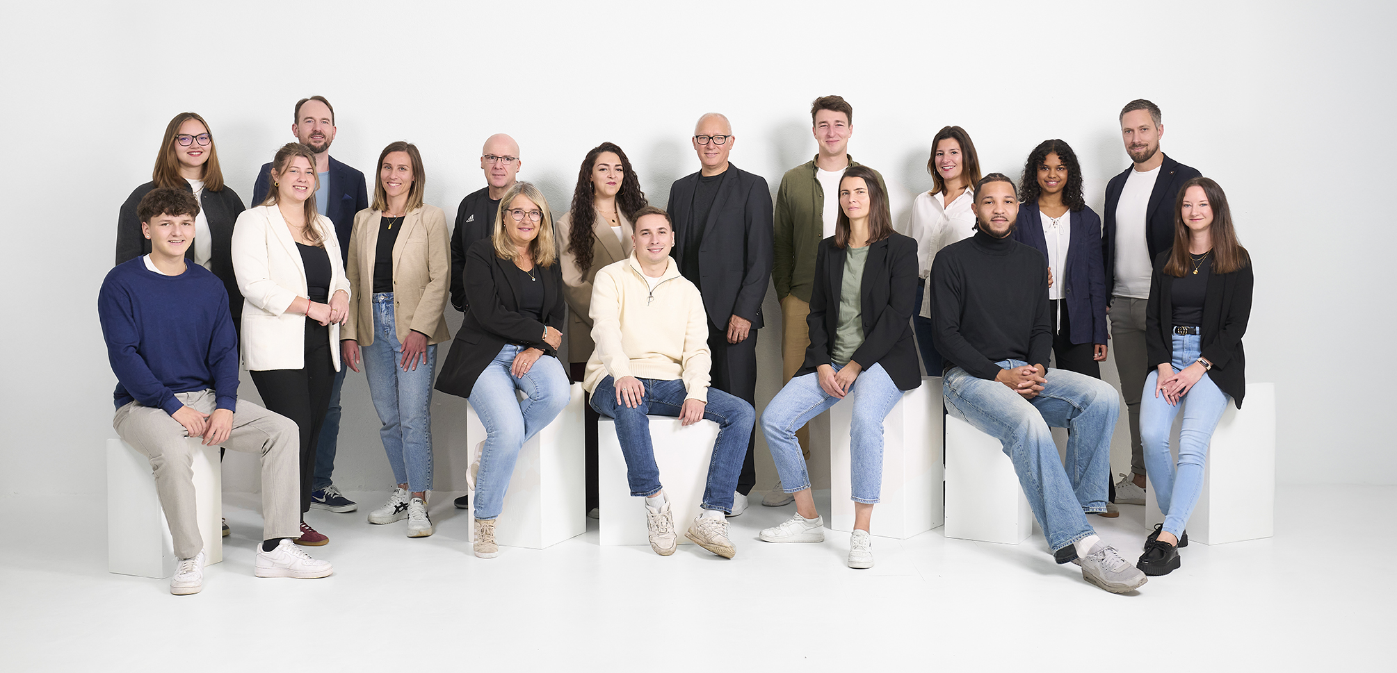 Das ganze Team der Holinger Moll Immobilien AG vor grauem Hintergrund.